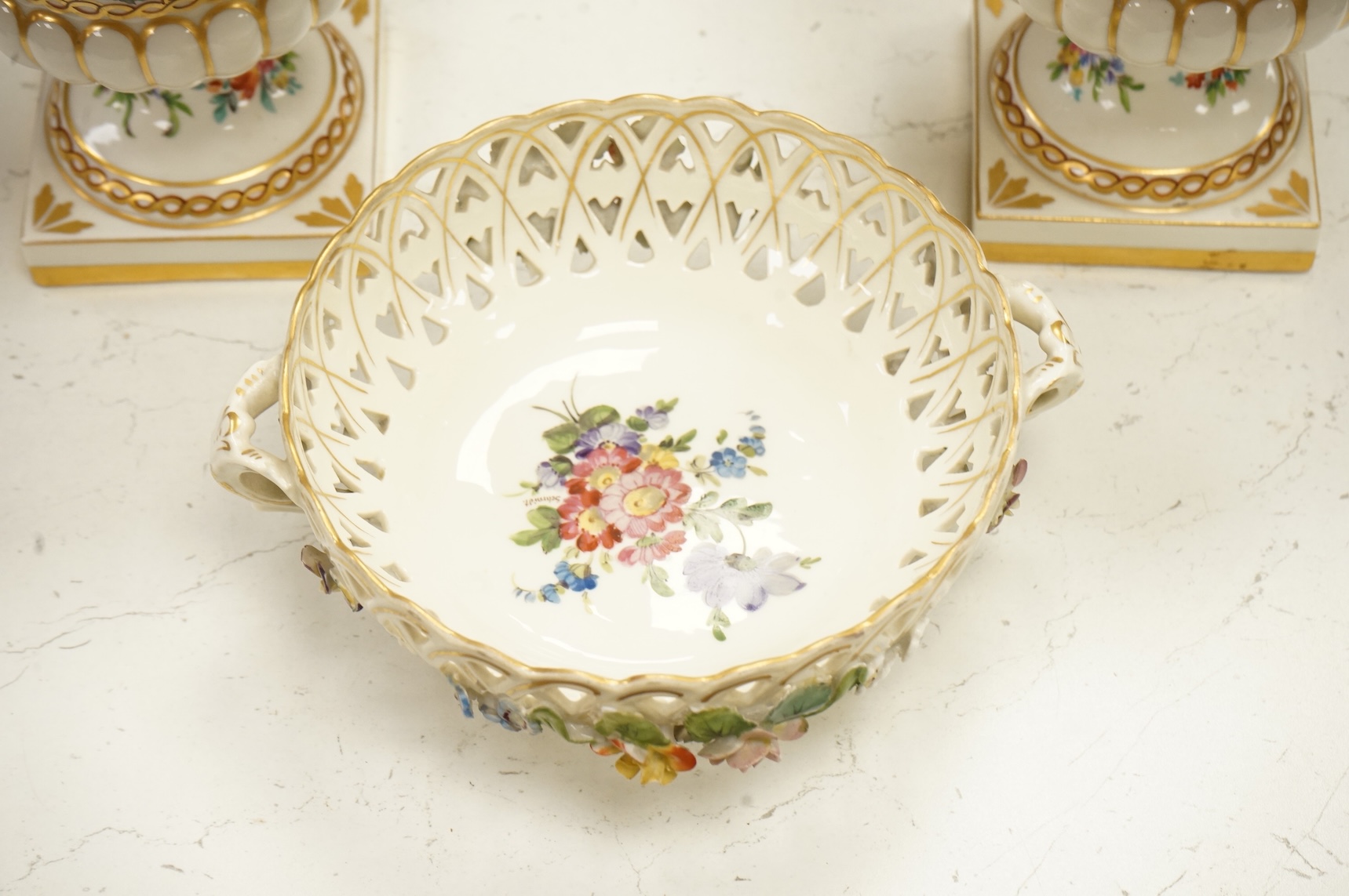 A pair of Dresden urns and a floral encrusted basket, tallest 15cm